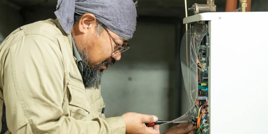 頭にタオルを巻き、眼鏡をかけて集中しながら配線作業に取り組んでいる