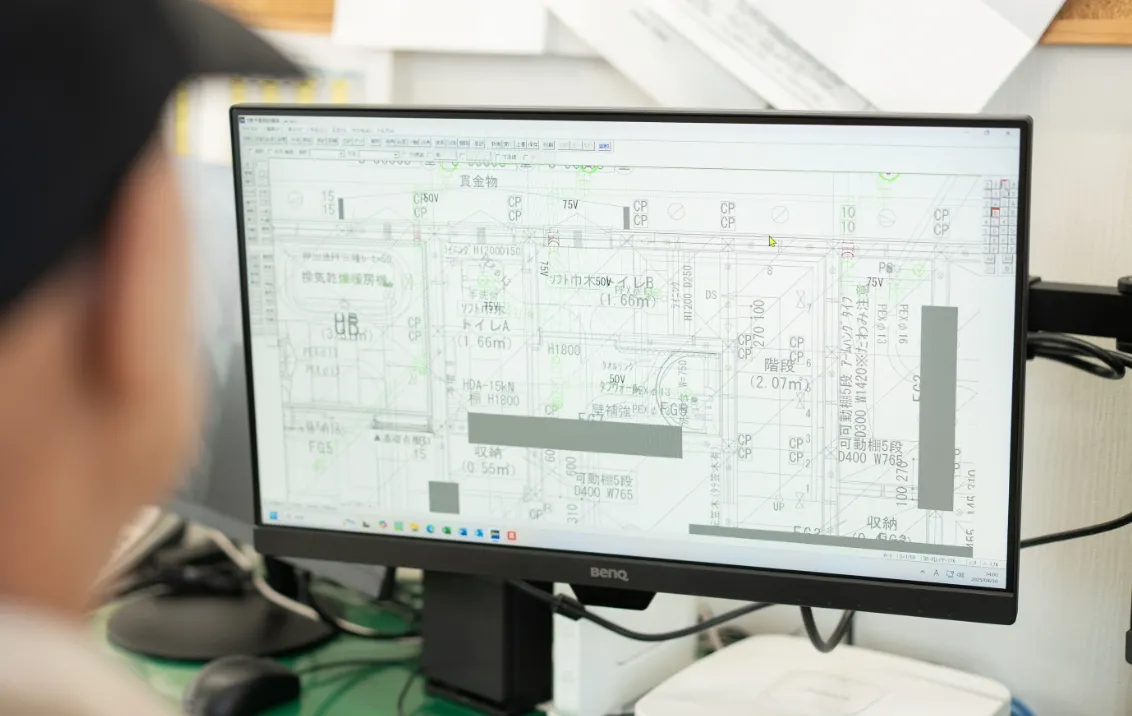 パソコンのモニターに建築や設備の詳細な設計図面が表示されている